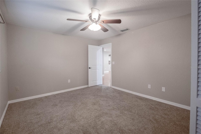 empty room featuring ceiling fan and carpet floors