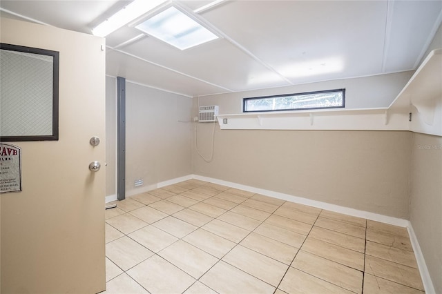 basement featuring a wall unit AC and light tile patterned flooring