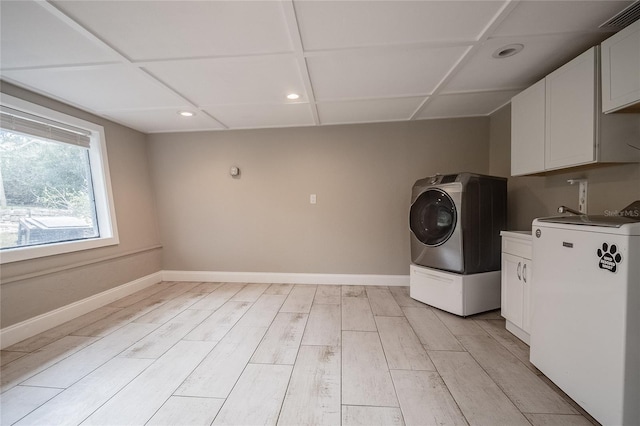 laundry room with cabinets, light wood-type flooring, and washer / clothes dryer