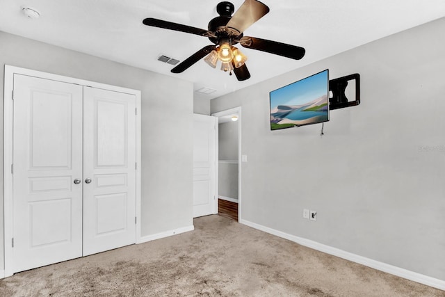 unfurnished bedroom with a closet, ceiling fan, and light colored carpet