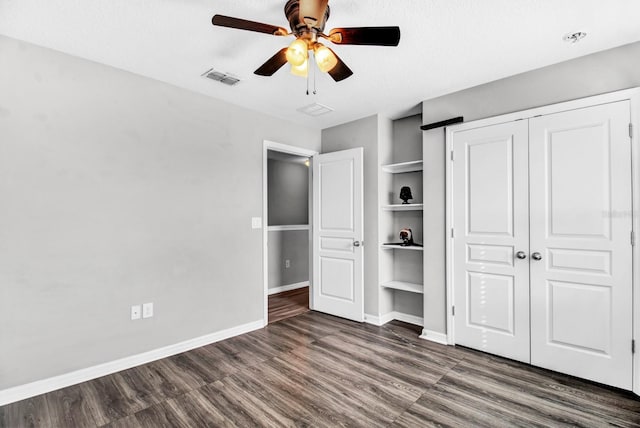 unfurnished bedroom featuring a textured ceiling, a closet, dark hardwood / wood-style floors, and ceiling fan