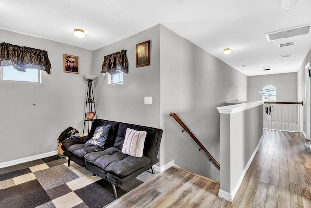 sitting room with hardwood / wood-style floors and a textured ceiling