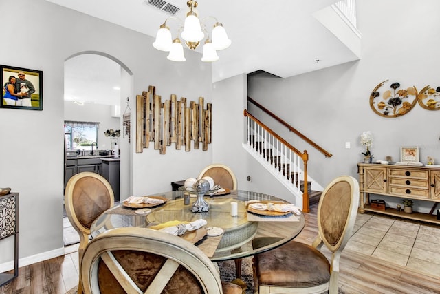 dining room featuring light wood-type flooring and an inviting chandelier