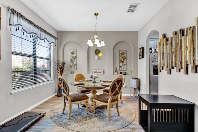 dining room featuring light hardwood / wood-style flooring and a chandelier