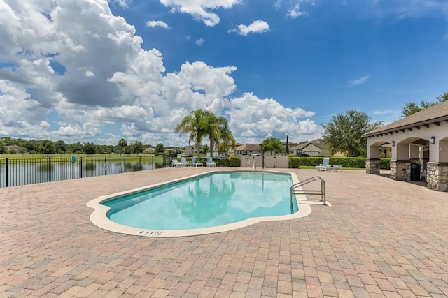 view of swimming pool with a water view and a patio