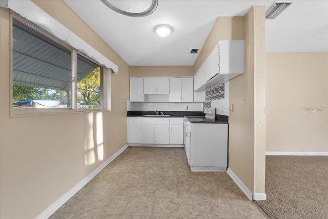 kitchen with white cabinetry, sink, light colored carpet, and electric range oven