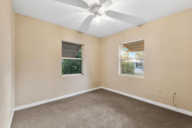 carpeted spare room featuring ceiling fan