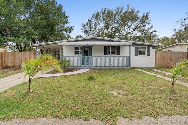 view of front of home with a front lawn, a porch, and a carport