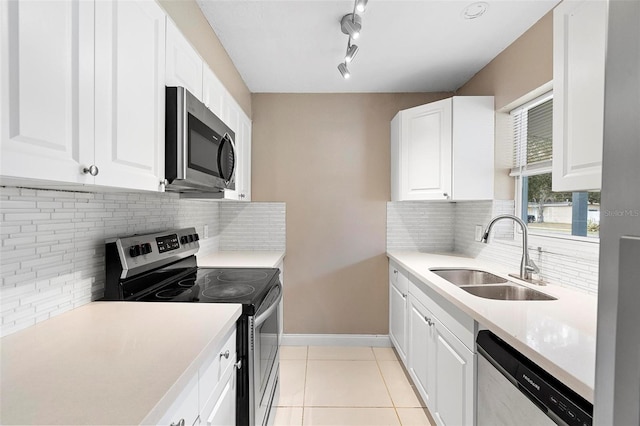 kitchen with white cabinetry, sink, tasteful backsplash, light tile patterned floors, and appliances with stainless steel finishes