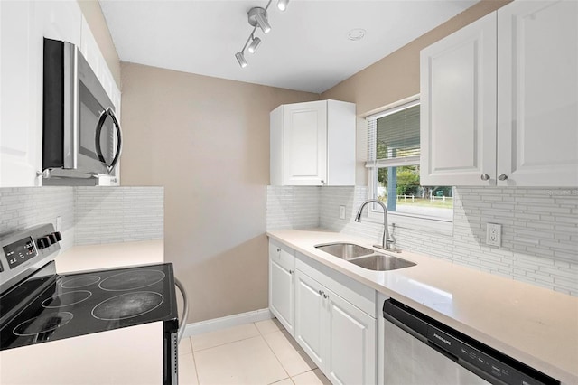 kitchen featuring light tile patterned floors, stainless steel appliances, white cabinetry, and sink