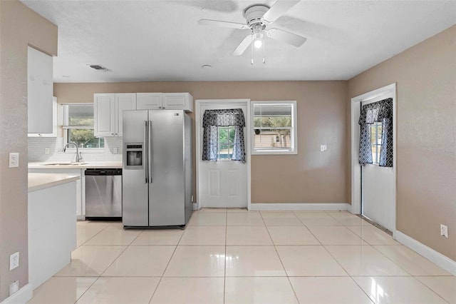 kitchen with white cabinets, appliances with stainless steel finishes, a healthy amount of sunlight, and sink