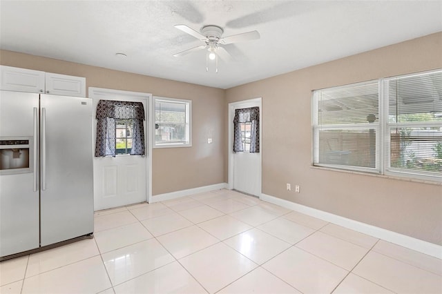 kitchen featuring ceiling fan, white cabinets, light tile patterned flooring, and stainless steel refrigerator with ice dispenser