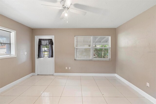 empty room featuring ceiling fan and light tile patterned floors