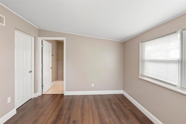 spare room with dark hardwood / wood-style flooring and ornamental molding