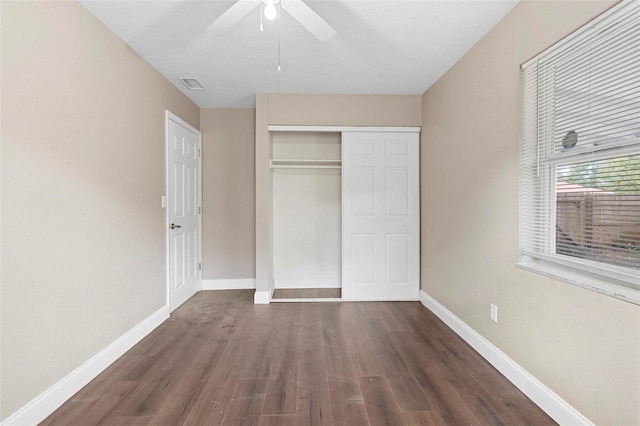 unfurnished bedroom with a closet, ceiling fan, and dark wood-type flooring