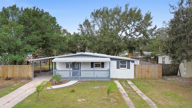 view of front facade with a carport, covered porch, and a front lawn