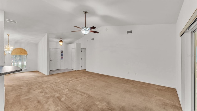 unfurnished living room featuring light carpet, ceiling fan with notable chandelier, and vaulted ceiling