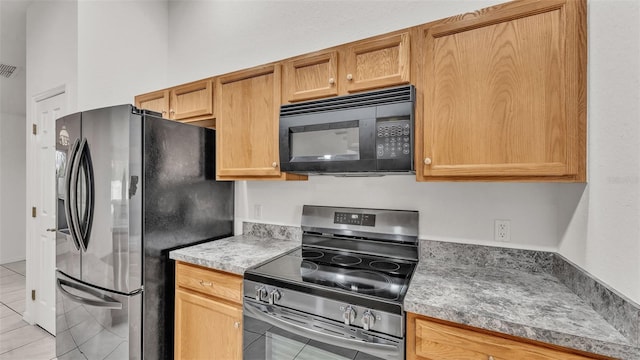 kitchen featuring light tile patterned flooring and stainless steel appliances