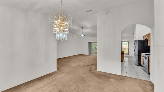 interior space with ceiling fan with notable chandelier, a towering ceiling, and light carpet