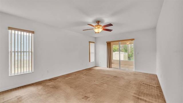 carpeted spare room featuring ceiling fan