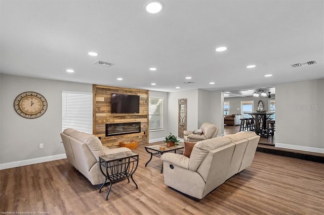 living room with light hardwood / wood-style flooring and a stone fireplace