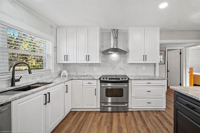 kitchen featuring white cabinetry, sink, stainless steel appliances, and wall chimney range hood