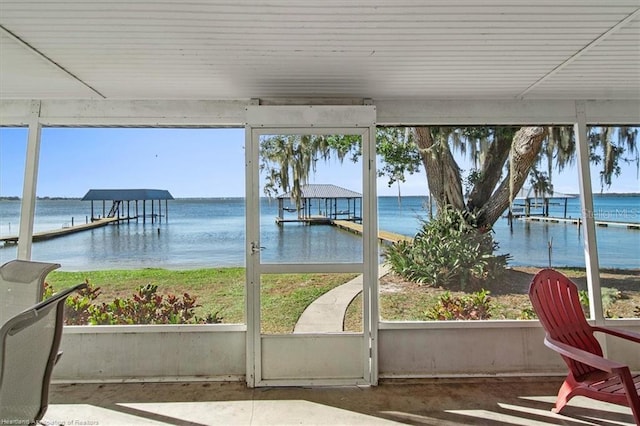 sunroom featuring a water view