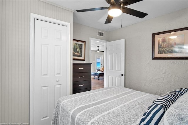 bedroom with hardwood / wood-style floors, ceiling fan, and a closet