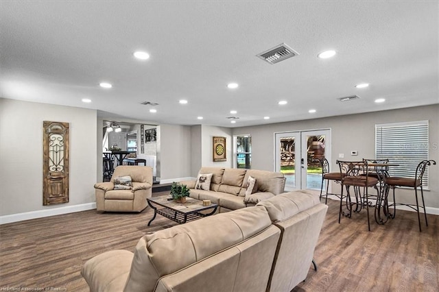 living room featuring ceiling fan, french doors, wood-type flooring, and a textured ceiling