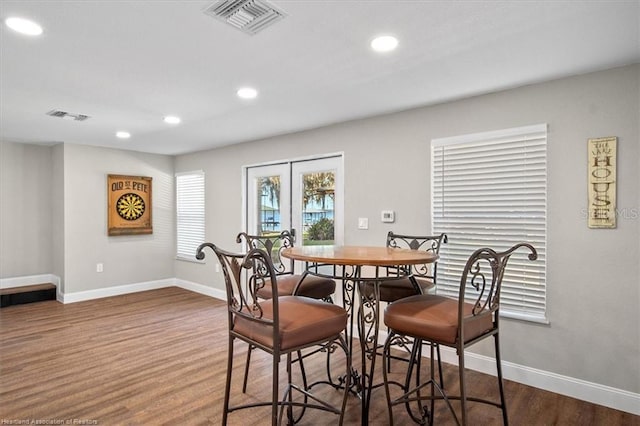 dining room with dark hardwood / wood-style flooring and french doors