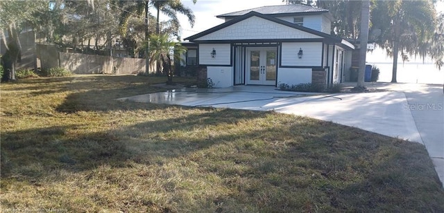 view of front of house featuring french doors and a front yard