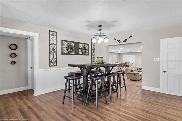 dining room featuring hardwood / wood-style floors and an inviting chandelier