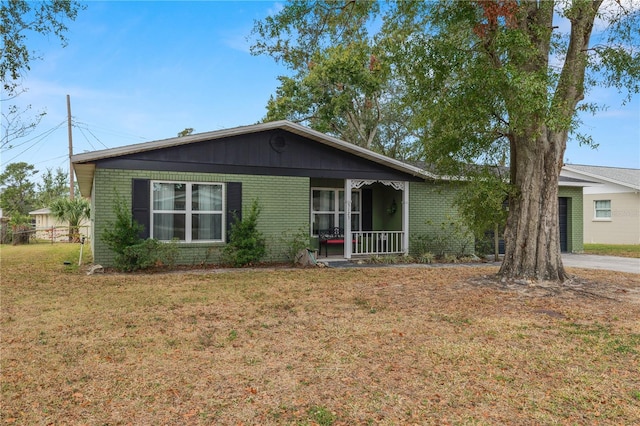 ranch-style house featuring covered porch and a front yard