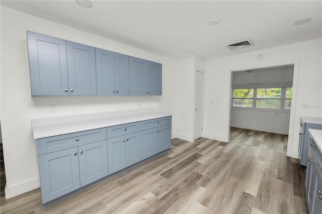 kitchen featuring blue cabinetry and light hardwood / wood-style flooring