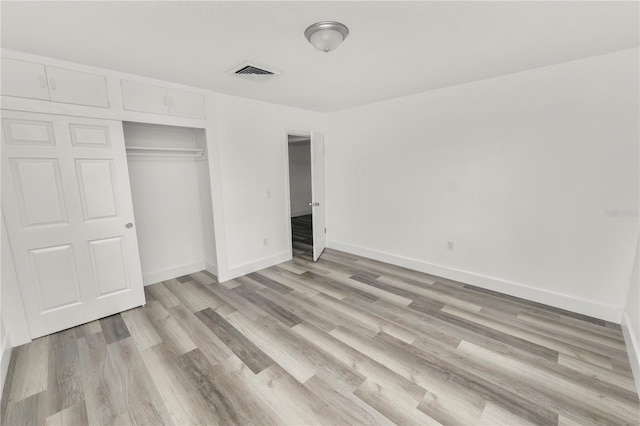 unfurnished bedroom featuring light wood-type flooring and a closet