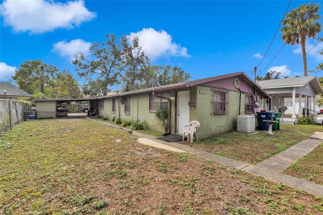 view of front of home featuring a carport, cooling unit, and a front yard