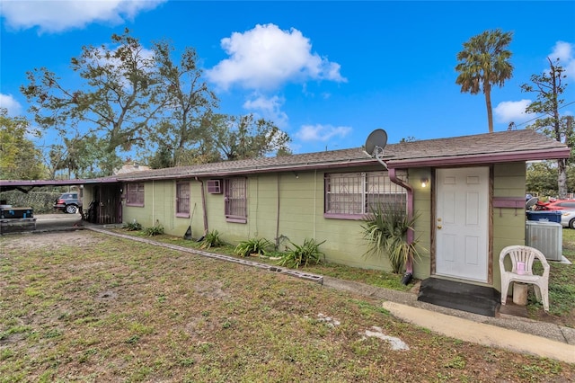 ranch-style house with central air condition unit and a carport