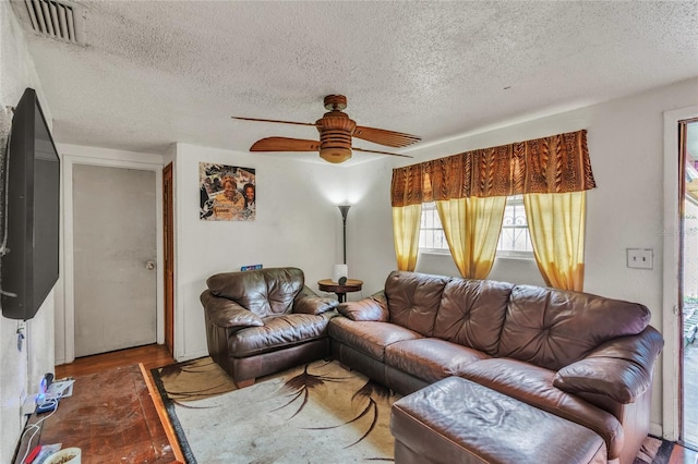 living room with ceiling fan, dark hardwood / wood-style floors, and a textured ceiling