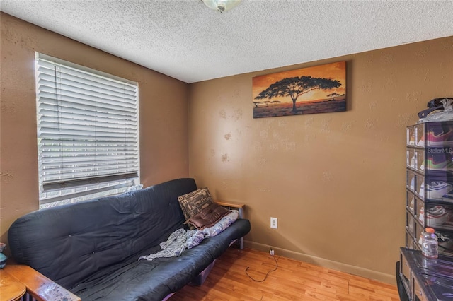 sitting room with hardwood / wood-style flooring, a textured ceiling, and a wealth of natural light