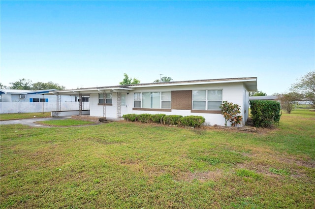 ranch-style home with a front lawn and a carport