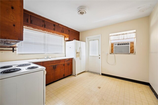 kitchen with cooling unit, white appliances, and sink