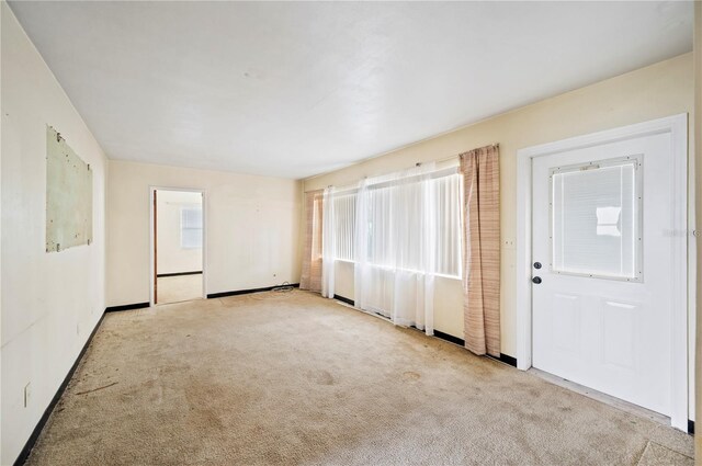 unfurnished room featuring light colored carpet