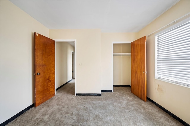 unfurnished bedroom featuring a closet and light colored carpet