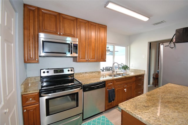 kitchen with sink, appliances with stainless steel finishes, and light hardwood / wood-style flooring