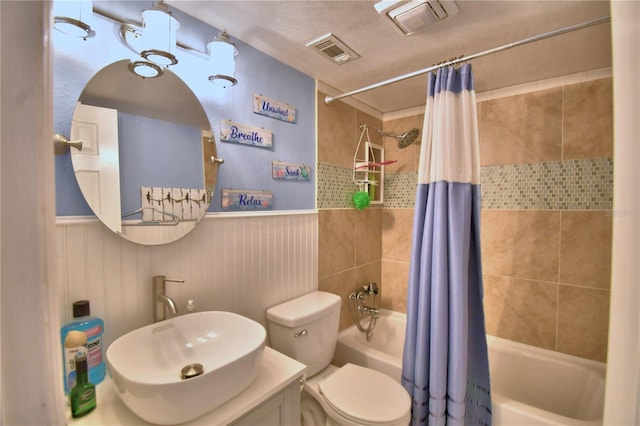 full bathroom with vanity, shower / bathtub combination with curtain, a textured ceiling, and toilet