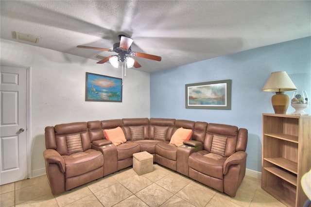 living room featuring ceiling fan, light tile patterned flooring, and a textured ceiling