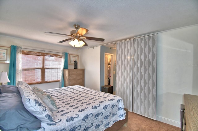 bedroom featuring ceiling fan, light colored carpet, and a textured ceiling