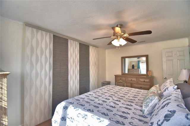 bedroom with a textured ceiling and ceiling fan