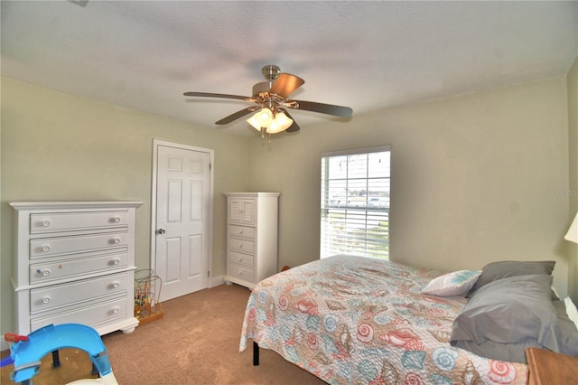 bedroom featuring carpet flooring, ceiling fan, and a textured ceiling