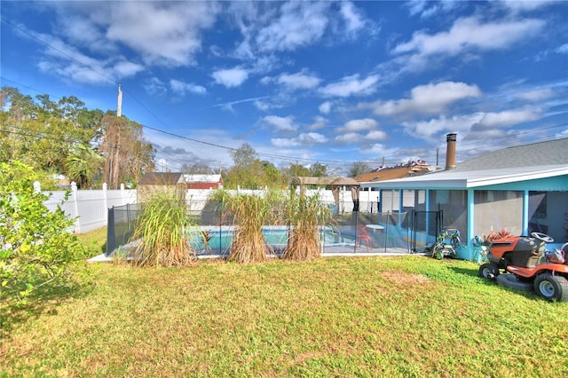 view of yard featuring a sunroom and a pool